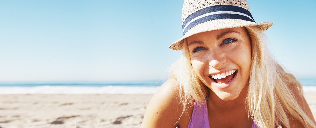 Young woman with flawless smile at the beach