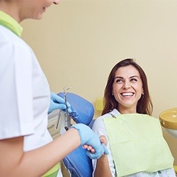 Woman in dental chair laughing