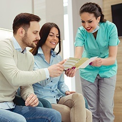 Man and woman talking to dental team member