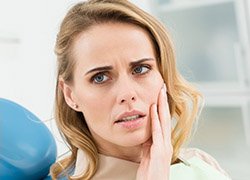 Woman holding jaw in pain