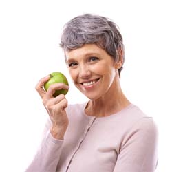 smiling woman holding a green apple