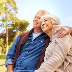 senior couple sitting on a park bench