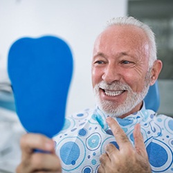 senior man admiring his new smile with dental implants