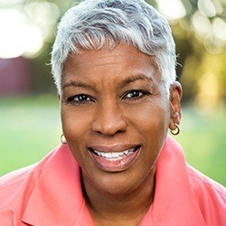 woman in a pink shirt smiling outside