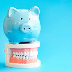Piggy bank and model teeth represent the cost of Invisalign