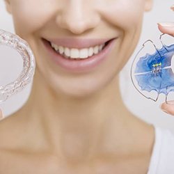 Smiling patient holding retainers after Invisalign in Myrtle Beach