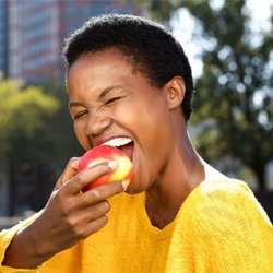 woman eating an apple with convenient Invisalign