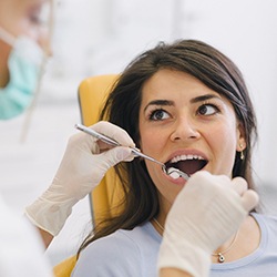 A dentist checking a female patient’s teeth after completing scaling and root planing