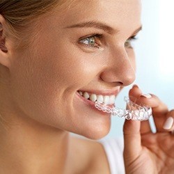 Woman placing Invisalign tray