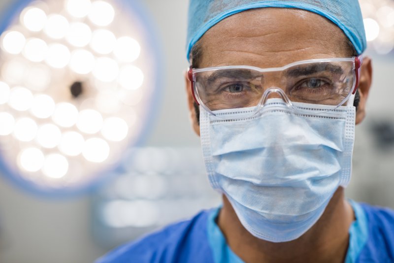 a male dentist wearing a mask and protective eyewear 
