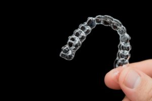 person holding Invisalign aligner